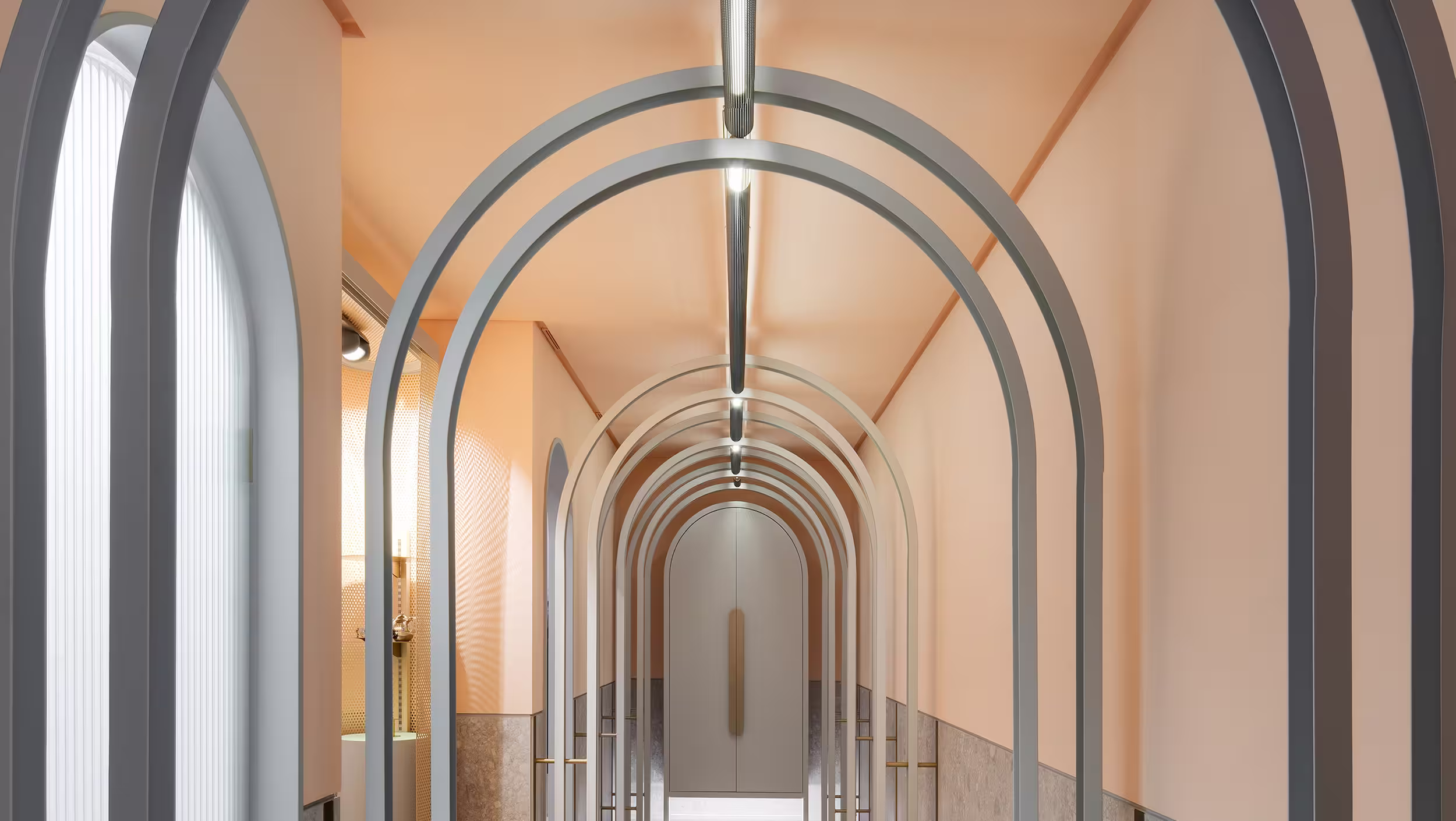Modern hallway with multiple nested gray archways, peach-colored walls, and a closed arched door at the end.