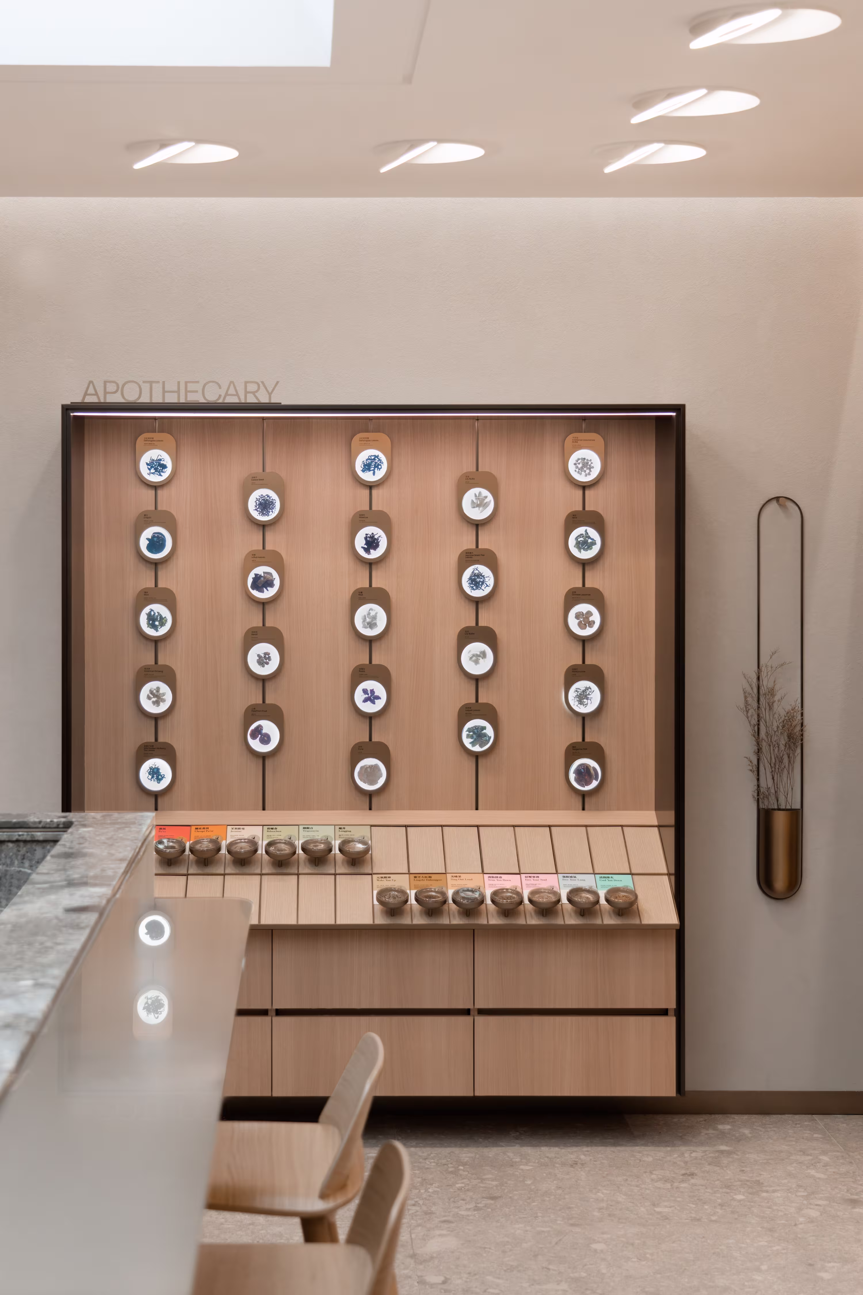 Tea Chateau full-width merchandising wall spanning all functional tea ranges with colour-coded bays under recessed ceiling lights