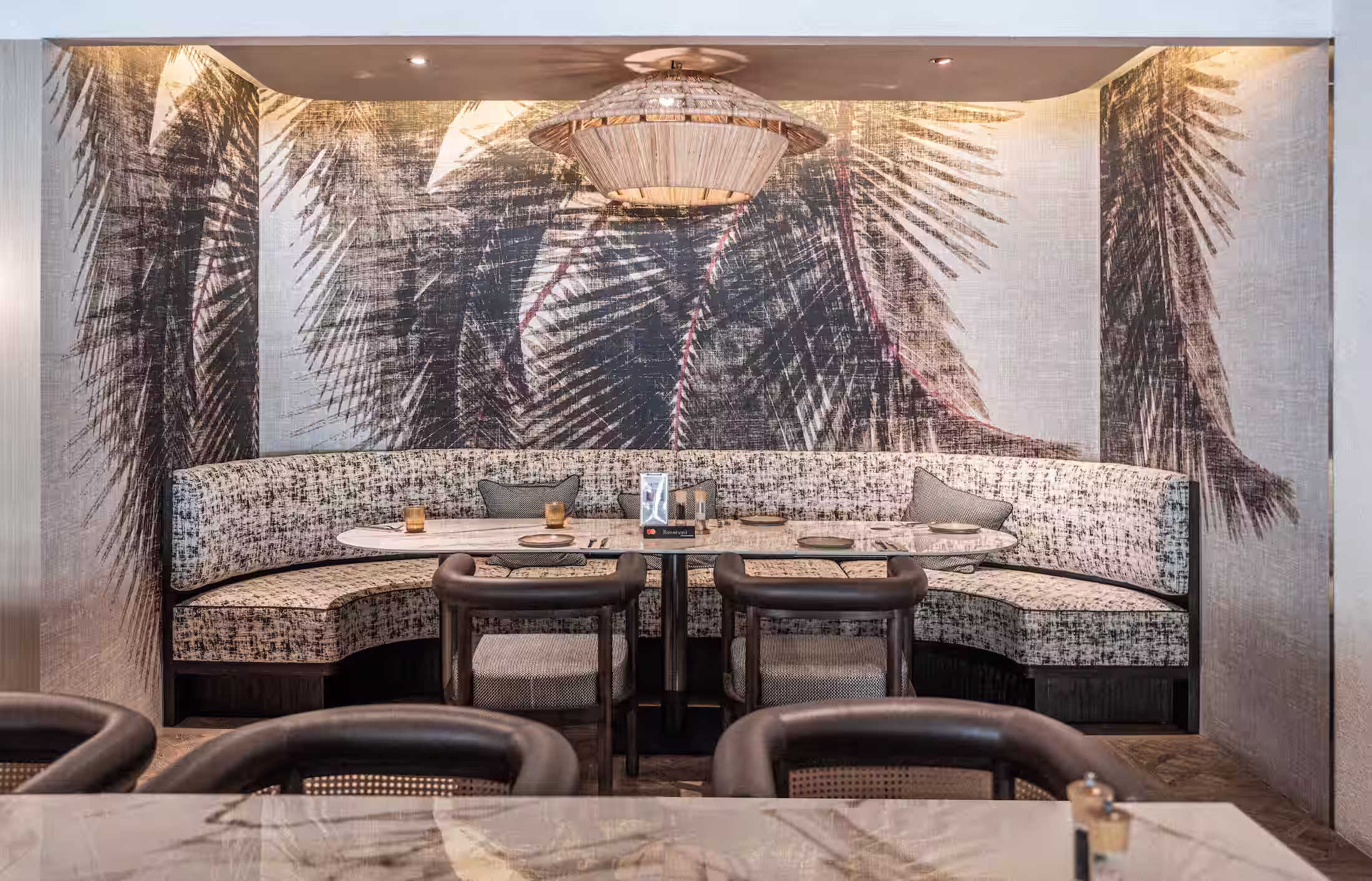 Latitude Bistro curved booth seating at ONE°15 Marina with patterned upholstery and timber chairs.
