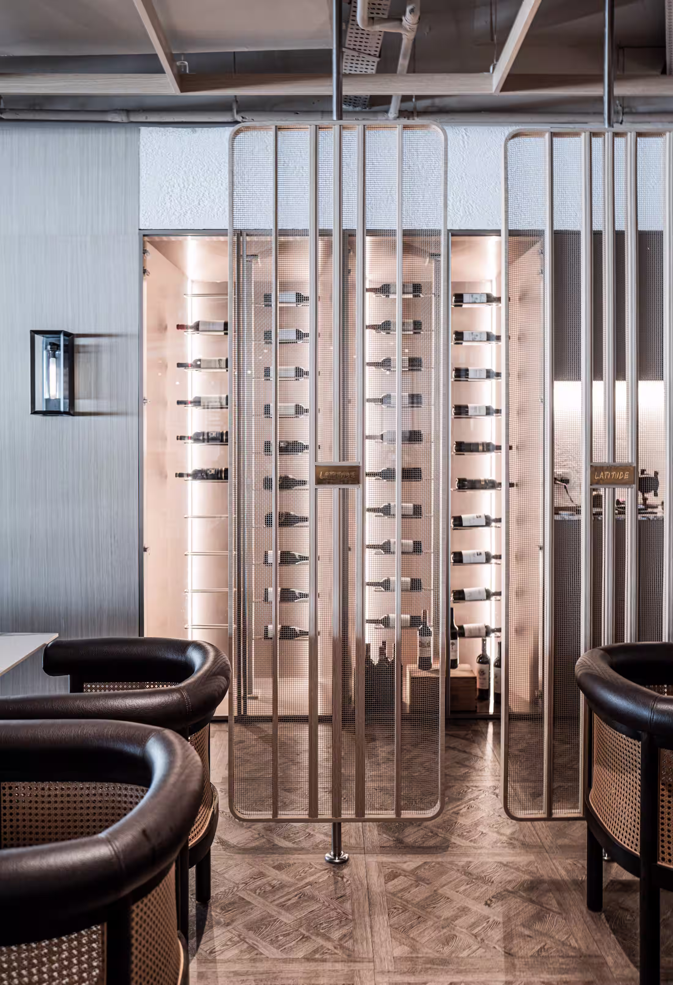 Wine storage display at Latitude Restaurant showing metal racks with horizontal wine bottles behind glass