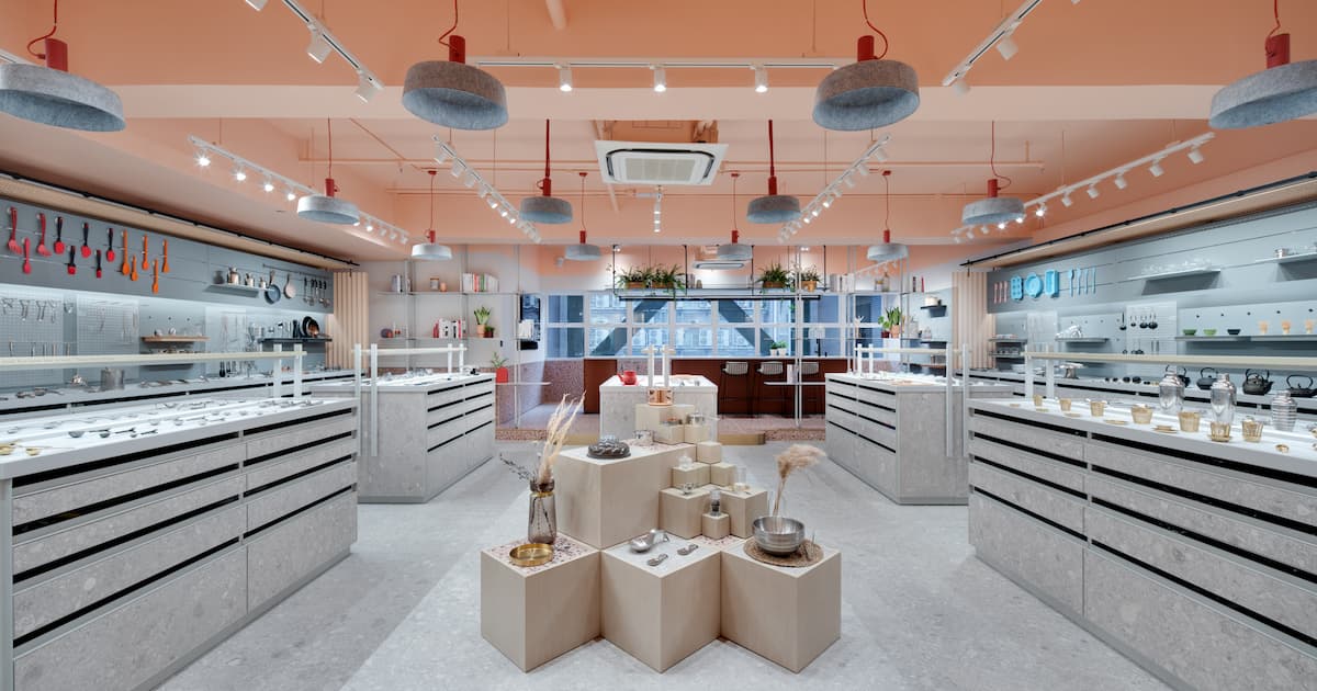 Lee Yuen Housewares showroom interior with kitchenware products arranged on geometric display pedestals, surrounded by perforated metal screens and pendant lighting