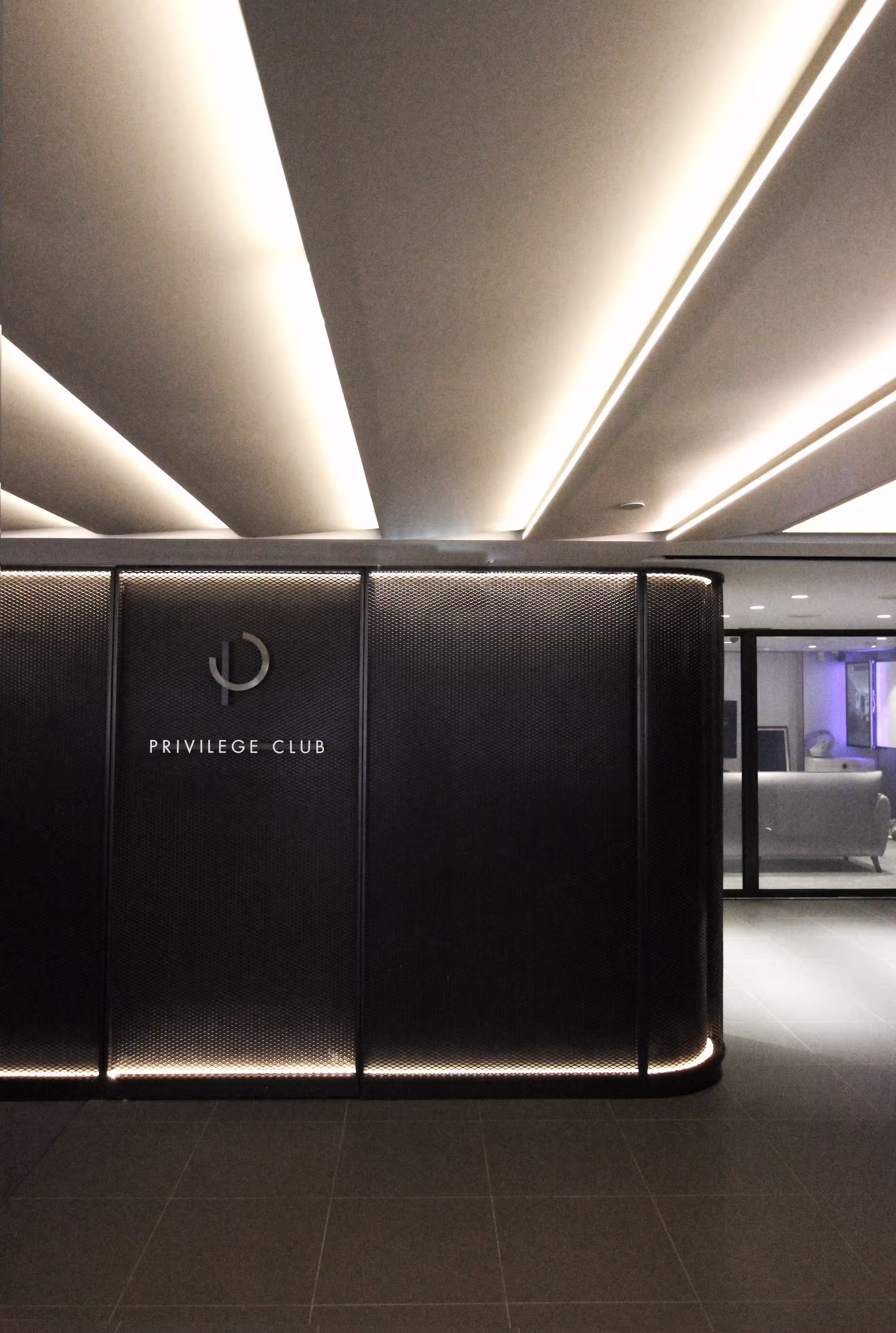 Feature wall in the China Mobile flagship store with radiating linear light beams around an illuminated logo plaque.