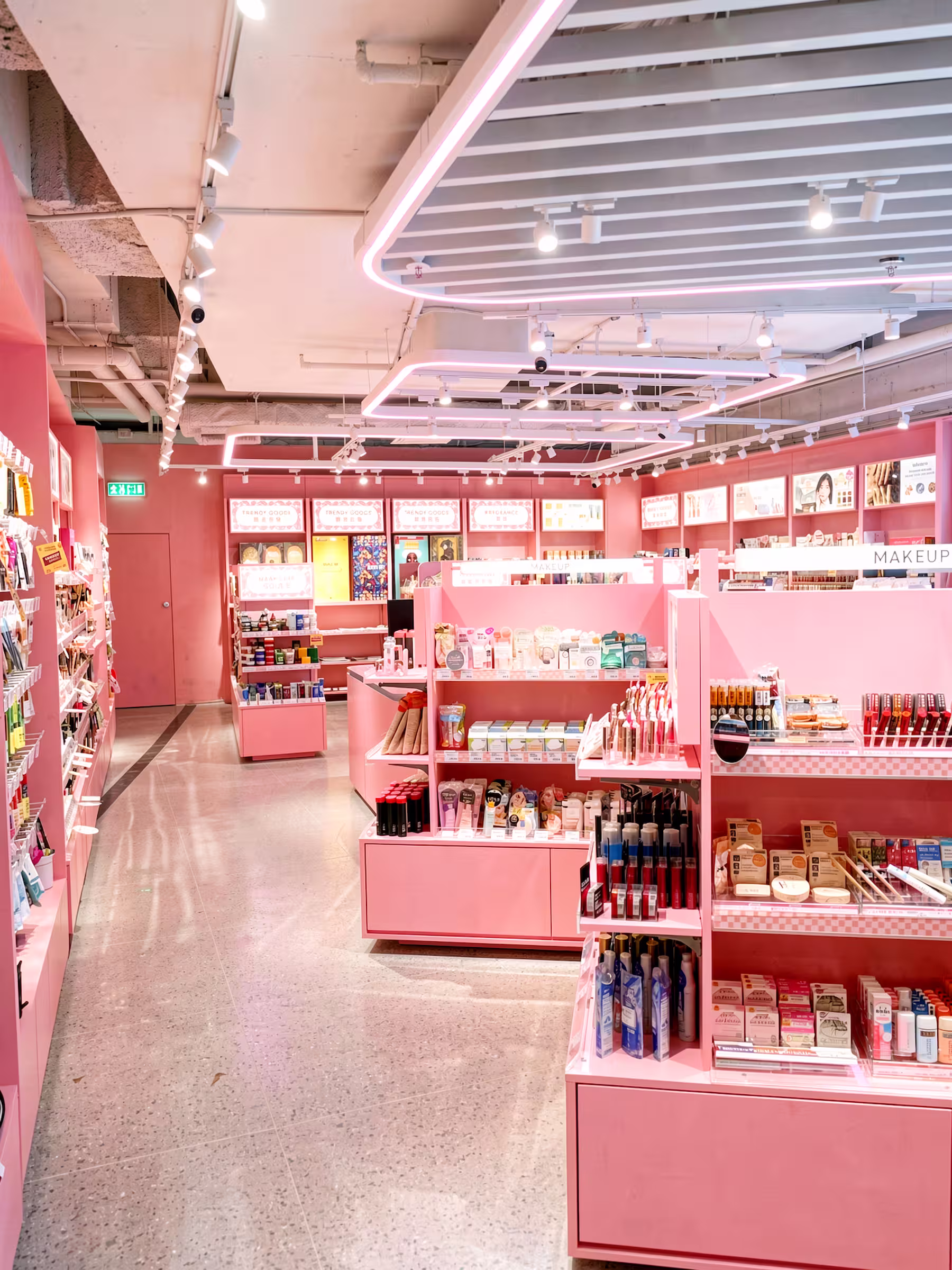 Wide view of the Tokyo Lifestyle department store concession with pink shelving units and cosmetics displays.