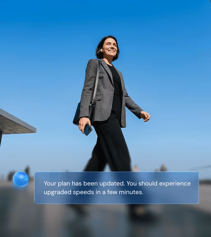 Smiling woman holding a phone and handbag, with a message overlay about plan update and upgraded speeds.