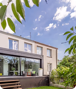 Maison moderne à deux étages avec de grandes baies vitrées