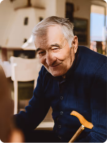 Un homme âgé vêtu d'un pull bleu foncé 