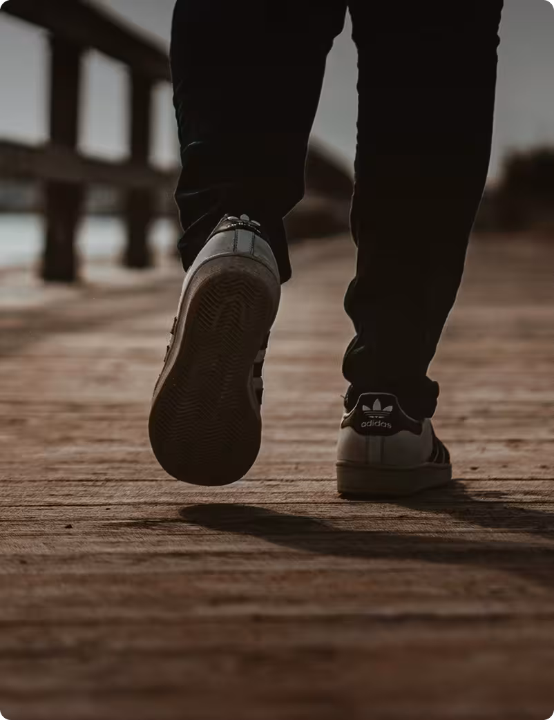 close-up of feet walking on a wooden boardwalk