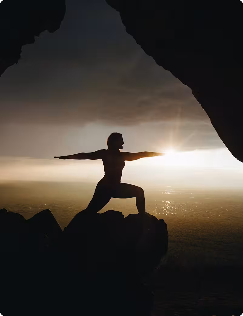 silhouette of a woman in a yoga pose with arms out