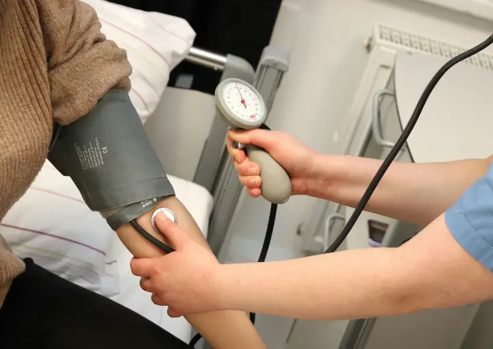 Naturopathic doctor checking a patient's blood pressure.