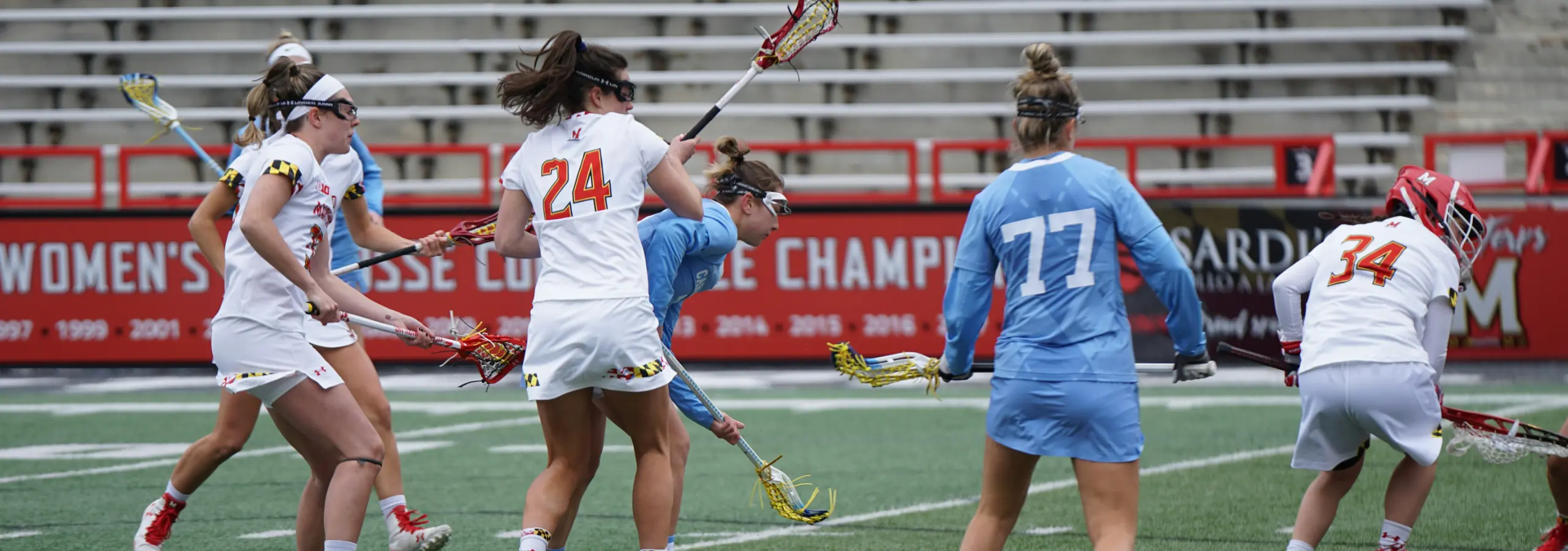womens' sports teams playing lacrosse on a sports field