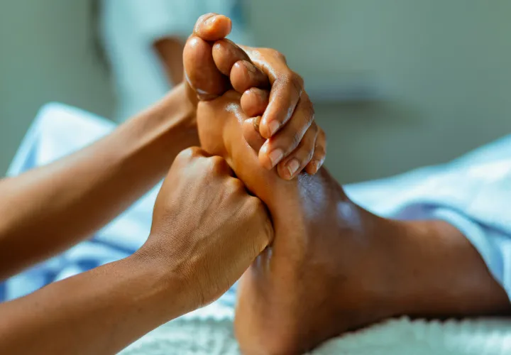 Close-up of a massage therapist massaging a patient's foot