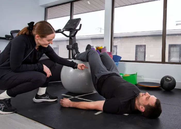 Therapist helping a man with pelvic core exercises