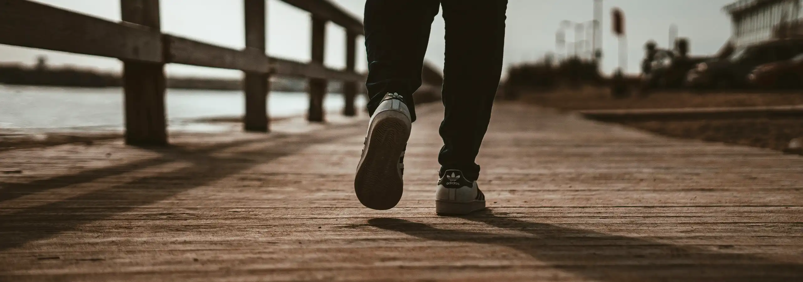 close-up of feet walking on a wooden boardwalk