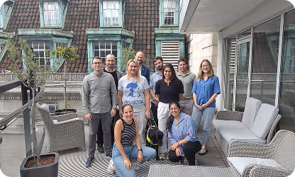 Team photo of diverse colleagues posing together on an outdoor patio