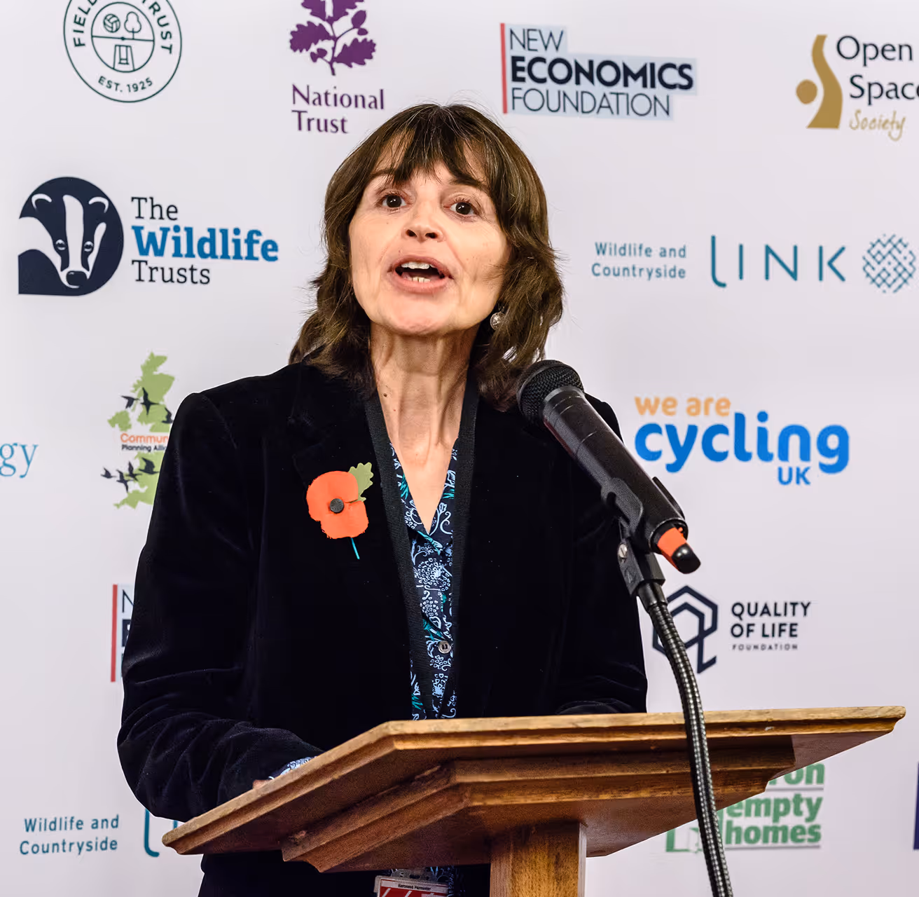 Speaker at podium with environmental organization logos giving presentation