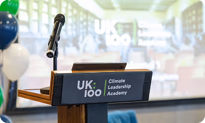 Podium with UK 100 Climate Leadership Academy microphone and logo