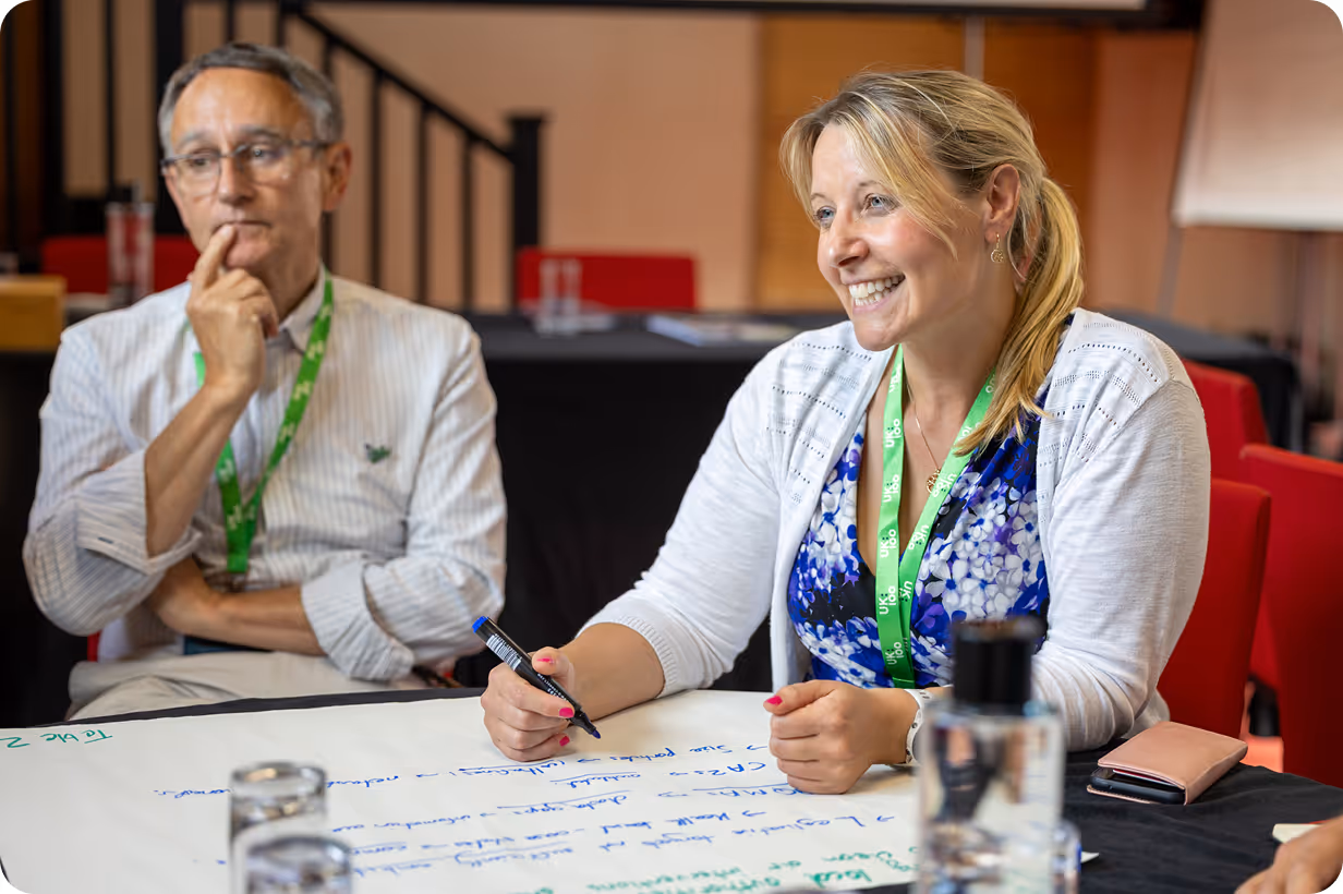 Two colleagues collaborating in a meeting, writing and discussing ideas