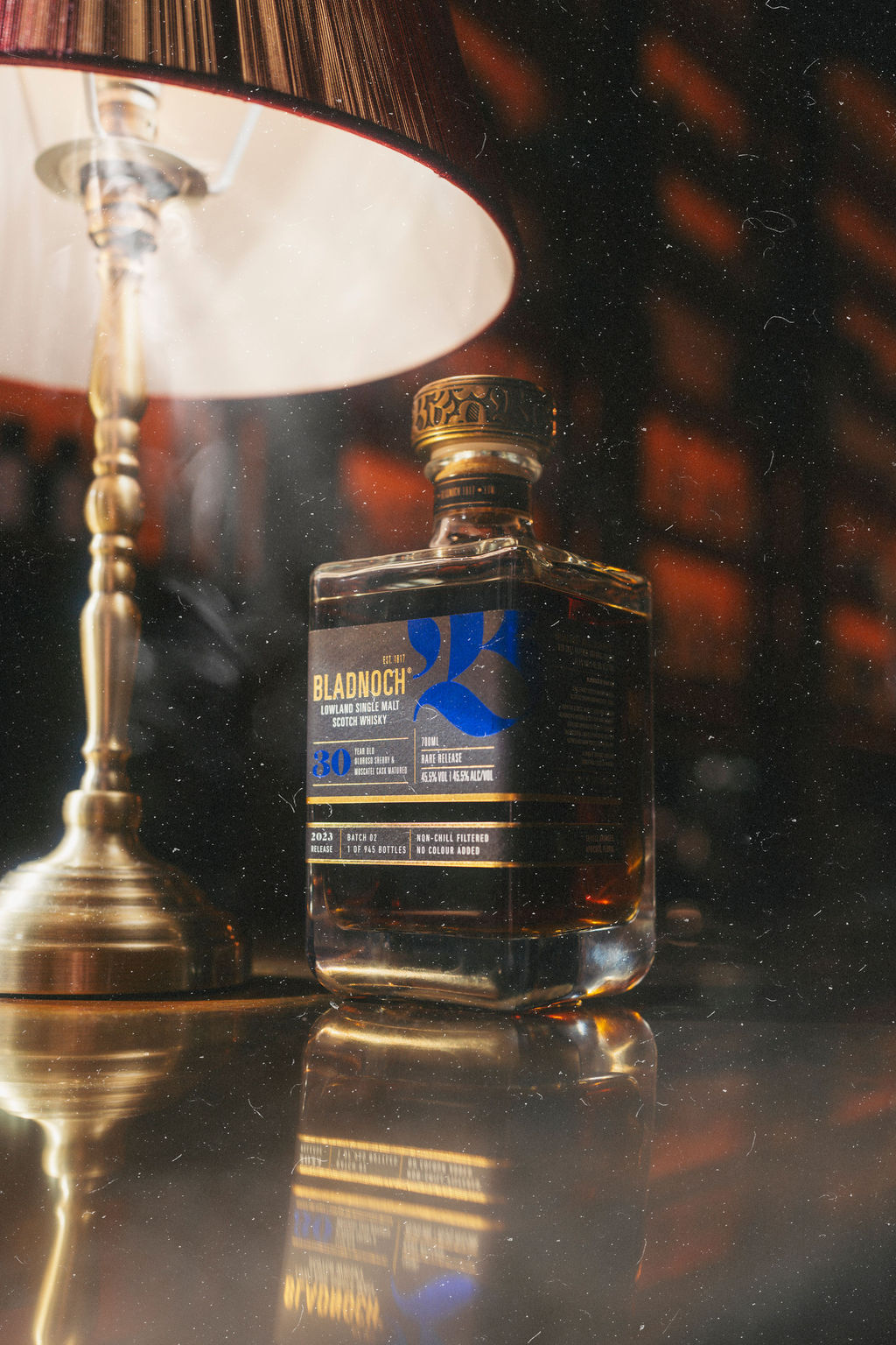 Bladnoch 30 Year Old bottle lit beside a brass candlestick