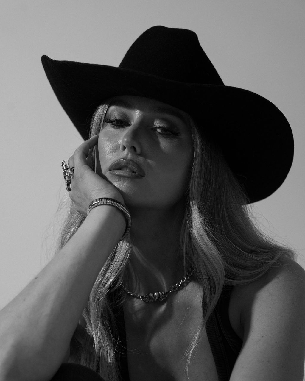 Ashleigh Greenwood with her hat brim low, black and white studio portrait