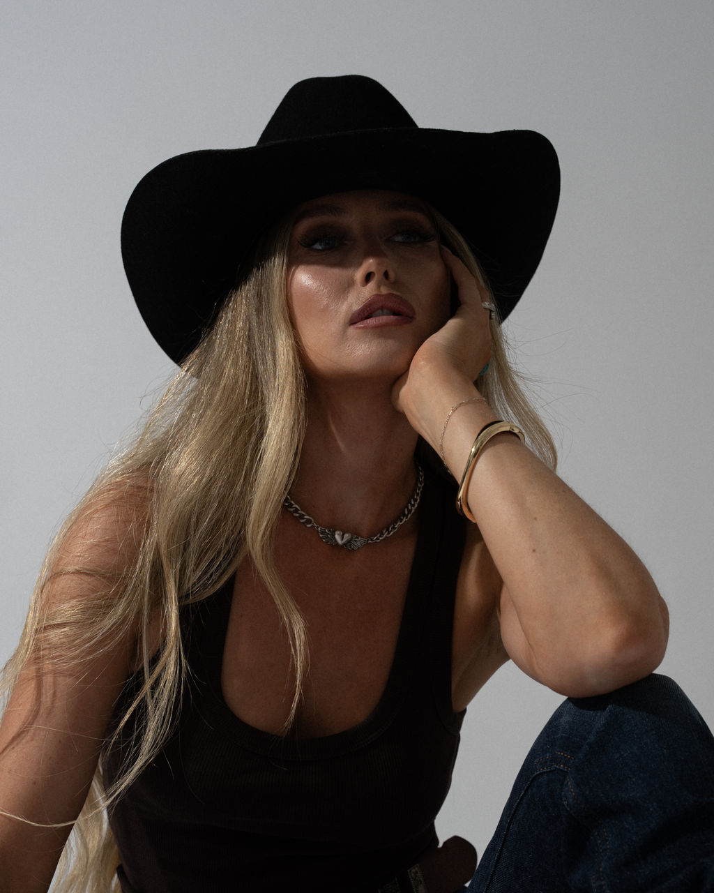 Ashleigh Greenwood in a black cowboy hat and vest, studio portrait
