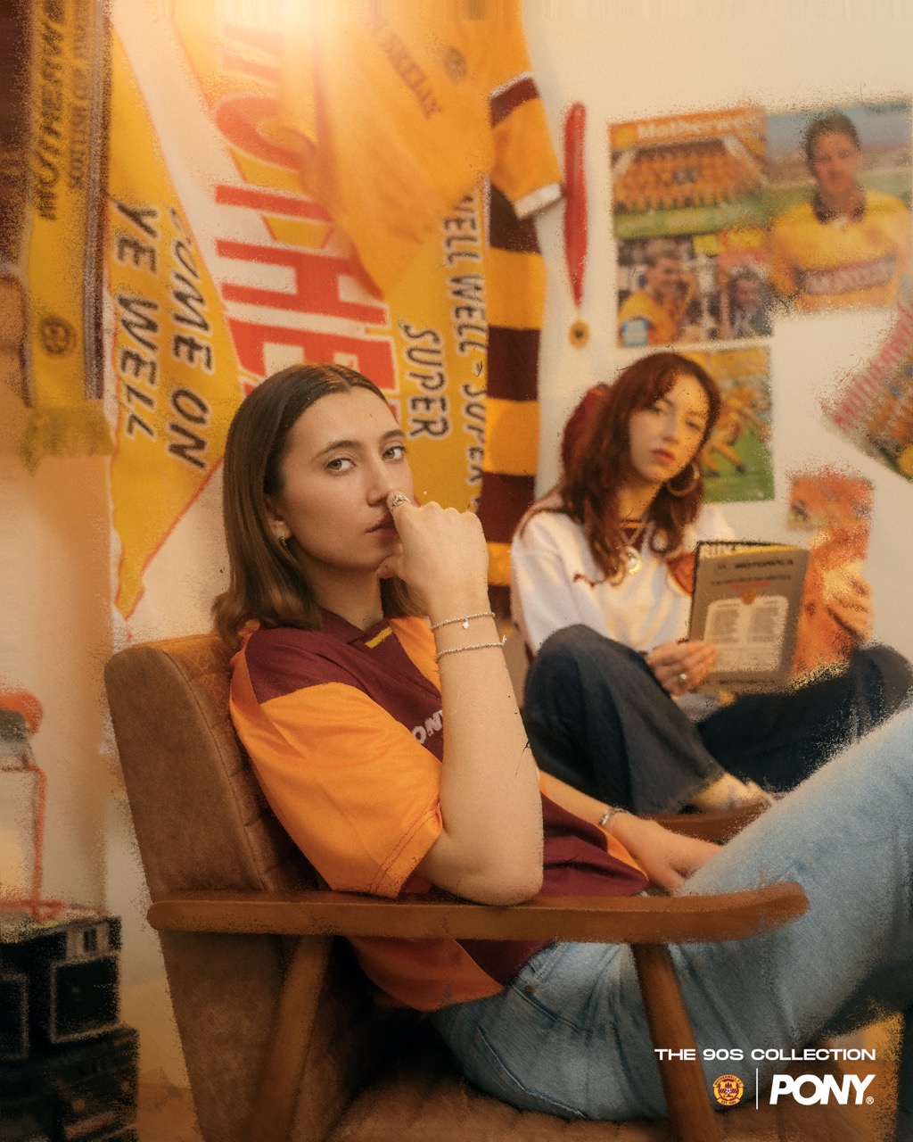A model in the Motherwell 90s home shirt on a leather armchair