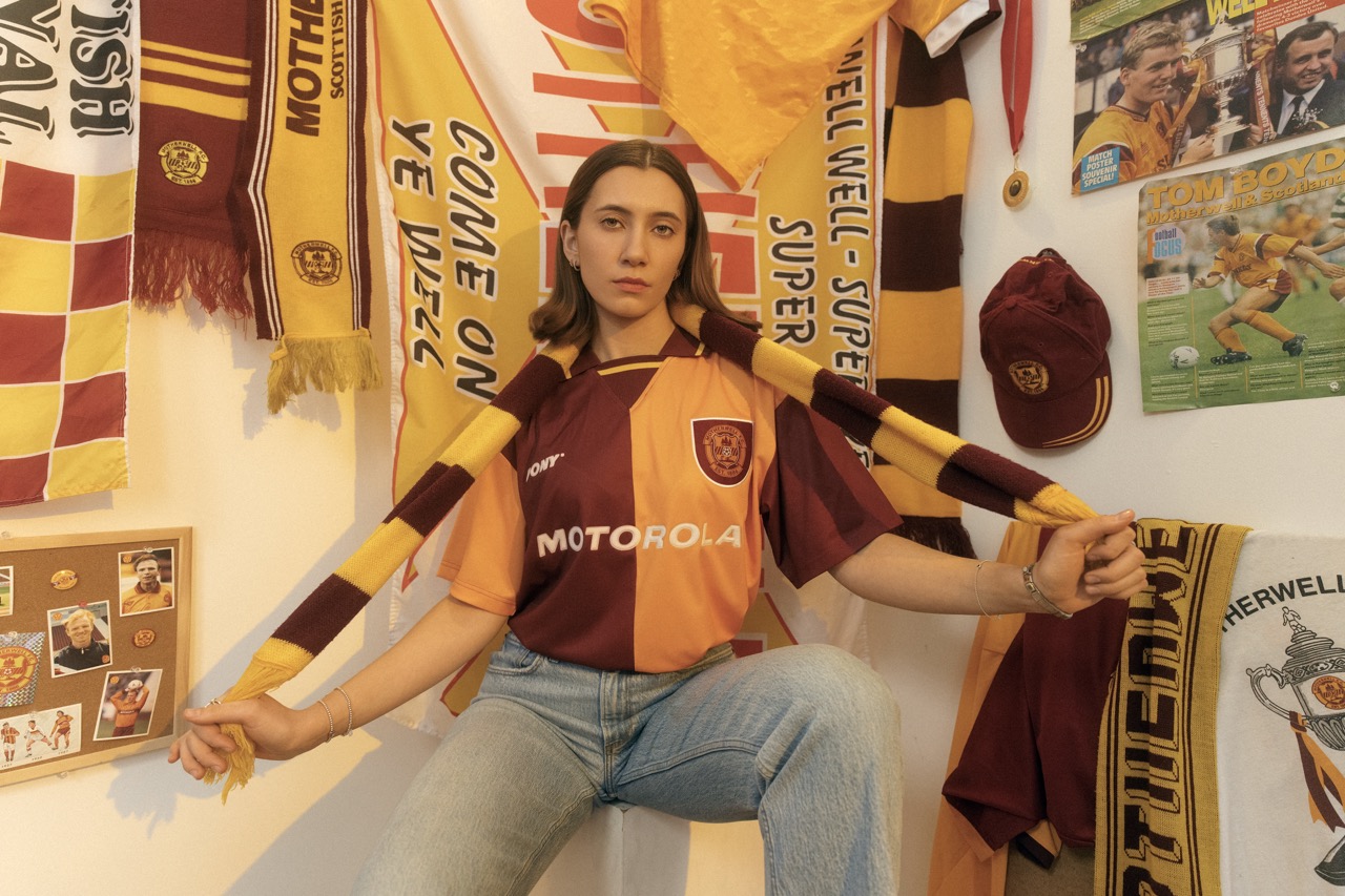A model in a Motherwell shirt surrounded by club scarves