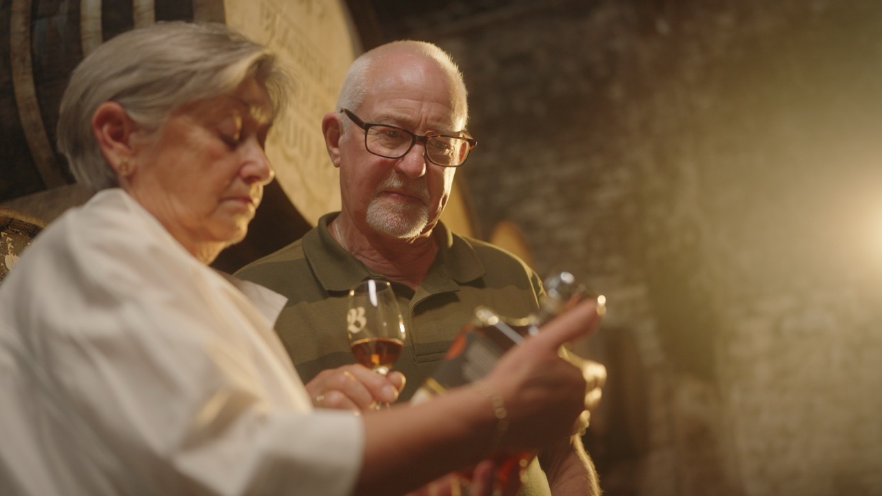 Roddy and Elaine nosing a glass in the warehouse
