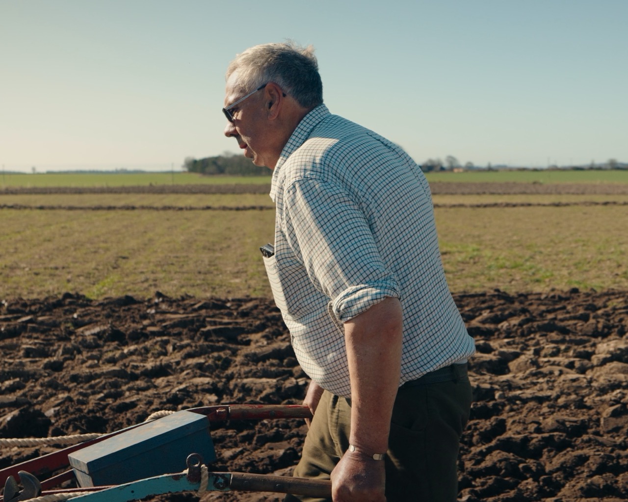 A man working at the edge of the ploughed field at Drummygar