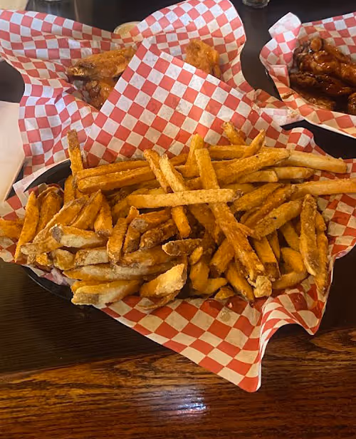A basket of french fries on a table.