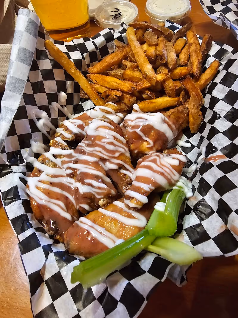 A basket of chicken wings with a white sauce.