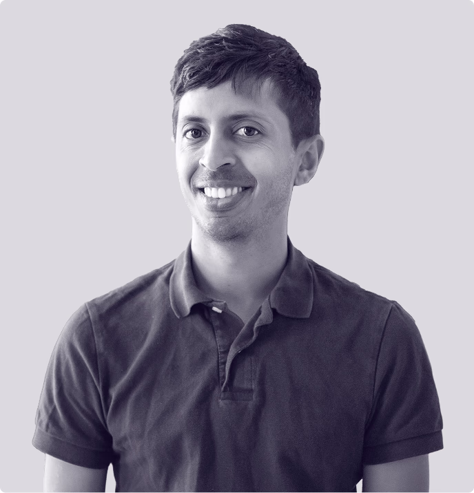 Smiling young man in a polo shirt, representing the approachable team culture at Faros AI on their website.