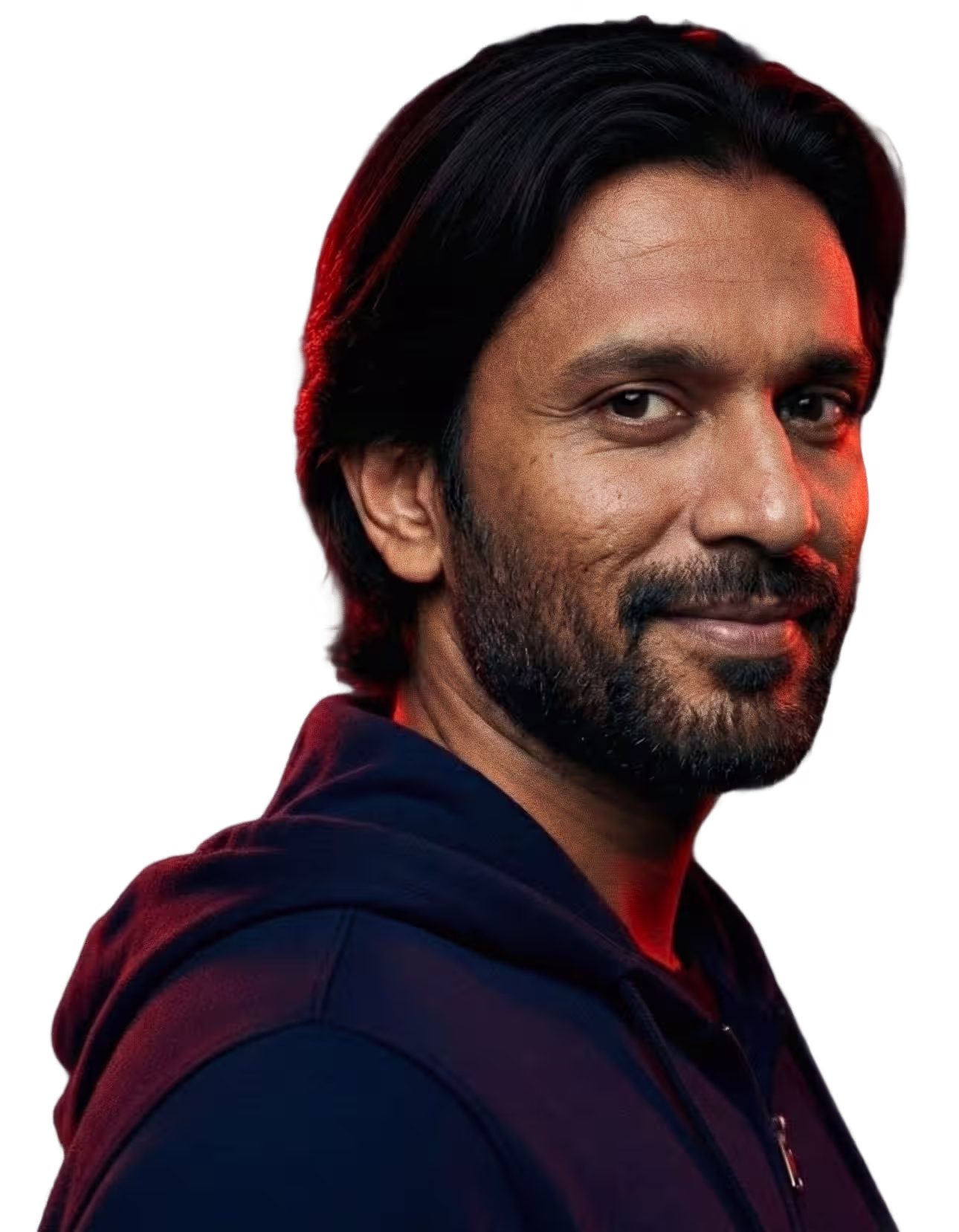 A confident man with dark hair and a beard smiles warmly against a dark background, representing Faros AI's innovation.