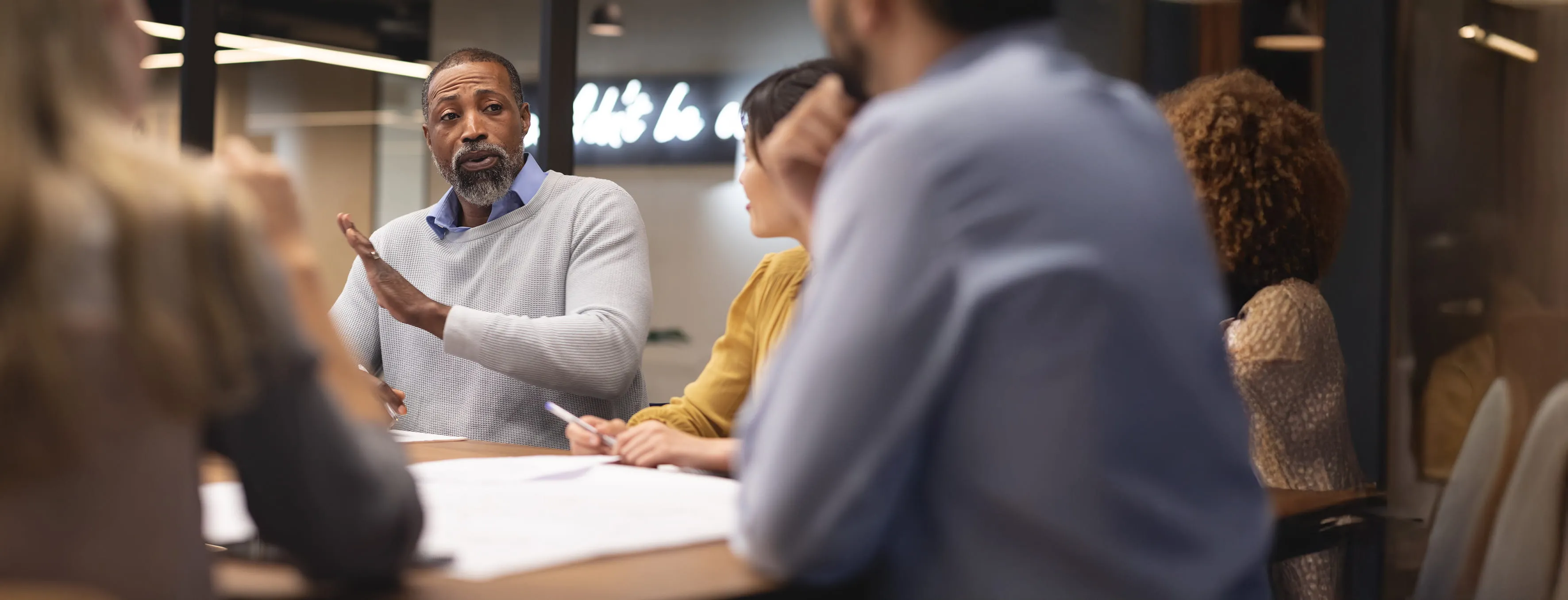 Group of business professionals having a discussion around a table in a modern office.