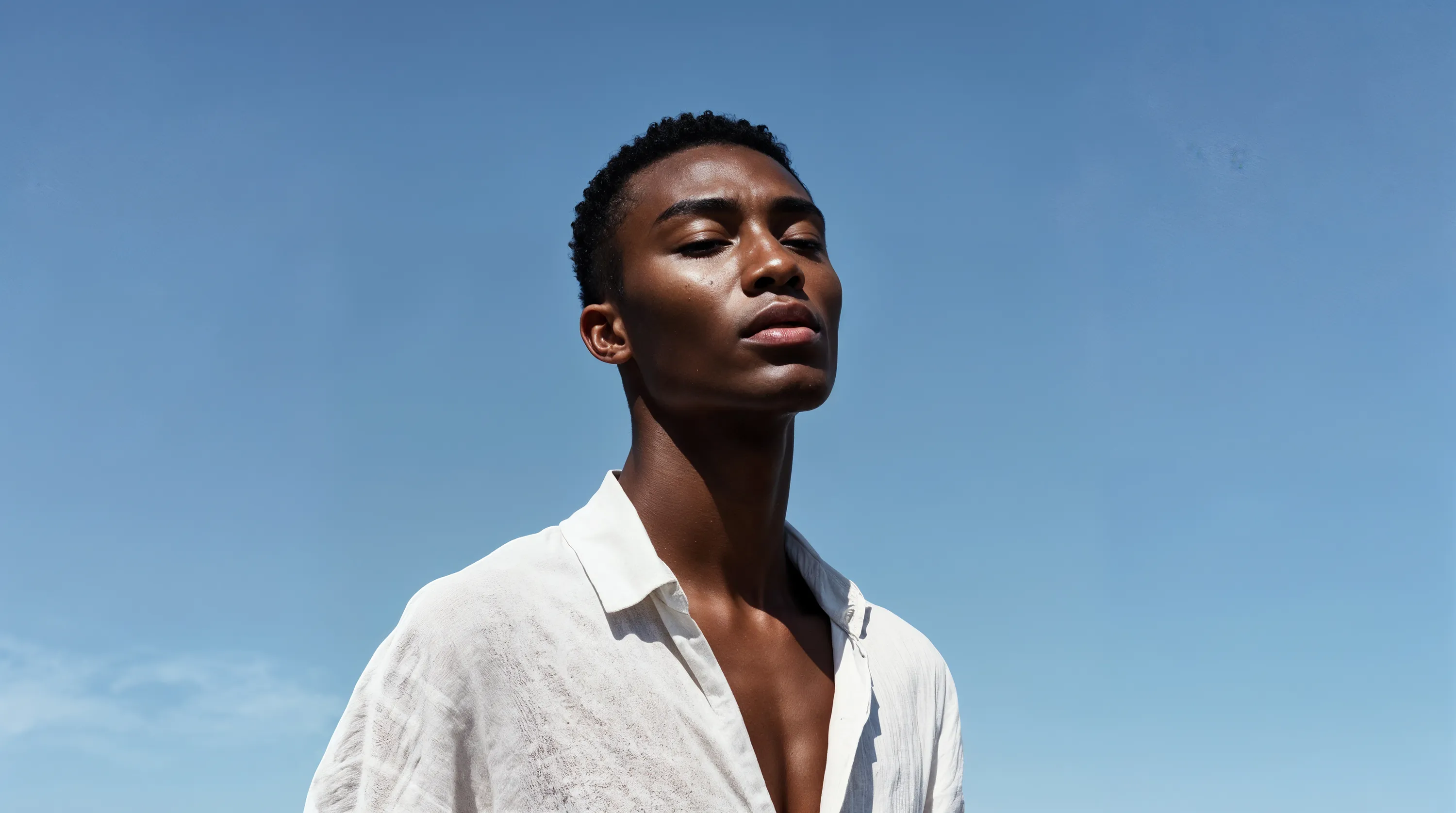 A man standing in front of a blue sky.