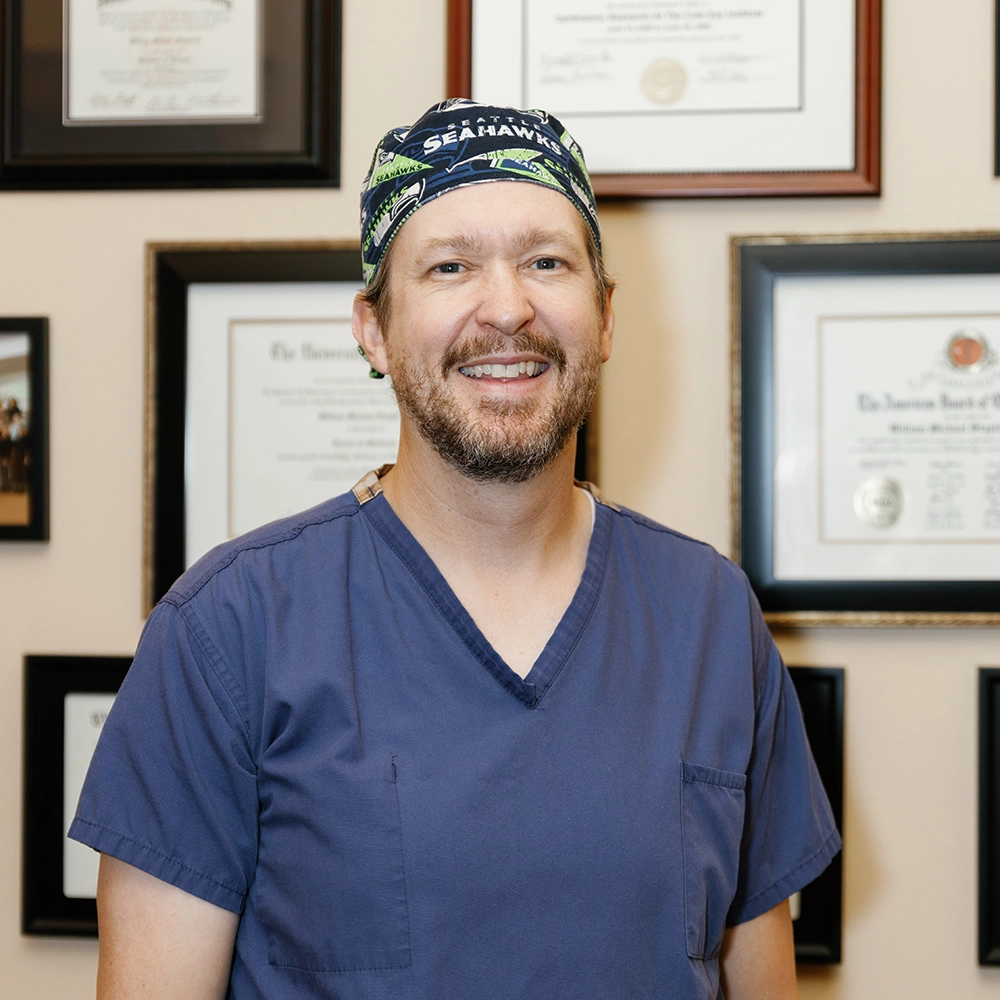 Dr. Stapleton, white male brown hair with a short beard, wearing blue scrubs and a Seahawks surgical cap