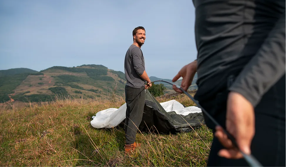 Homme souriant sur l'alpage lors d'une activité en plein air – Whitepod, hôtel insolite dans les Alpes suisses