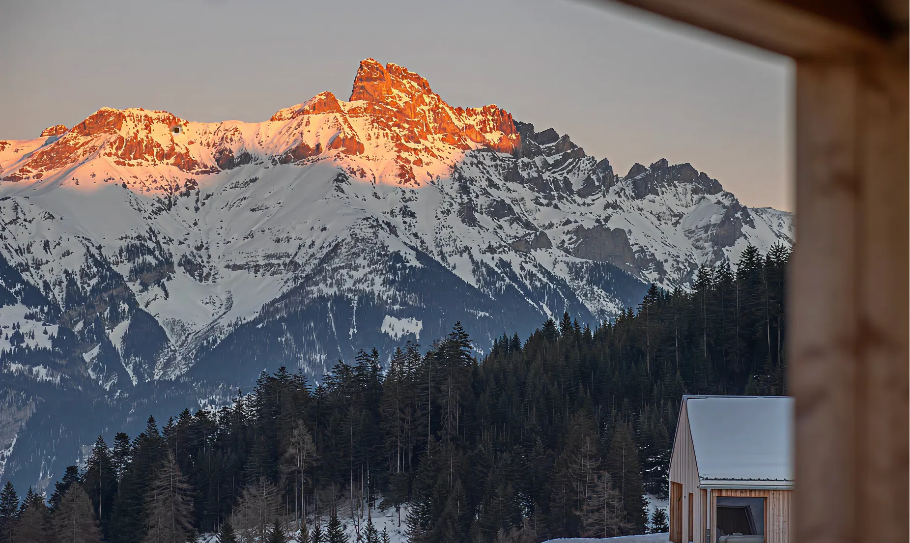 Sommets enneigés au coucher du soleil depuis la terrasse d'un chalet – Whitepod, hôtel insolite dans les Alpes suisses