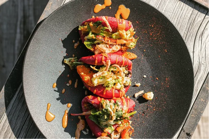 Légumes grillés et sauce dressés sur une assiette noire – restaurant Les Cerniers au-dessus de Monthey