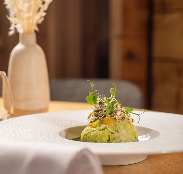 Entrée raffinée dressée dans une assiette creuse blanche – restaurant Les Cerniers au-dessus de Monthey
