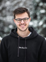 Portrait d'un client souriant à lunettes et sweat noir – Whitepod, hôtel insolite dans les Alpes suisses