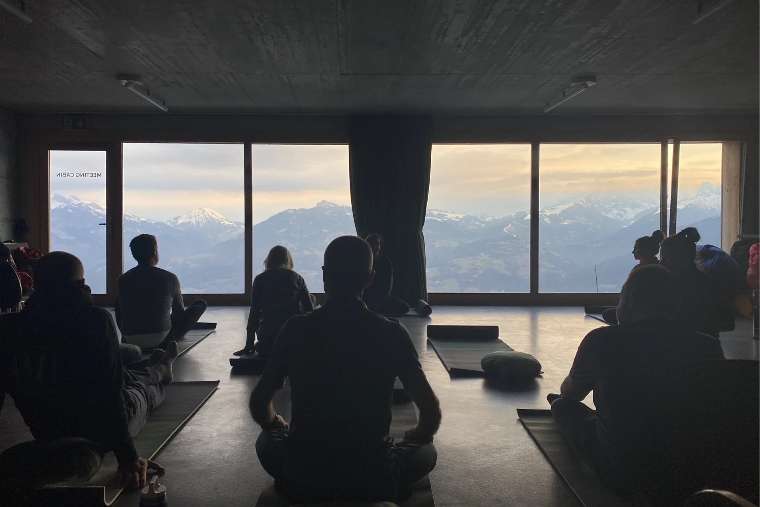 Séance de méditation en groupe dans une salle face aux montagnes – Whitepod, hôtel bulle dans les Alpes suisses
