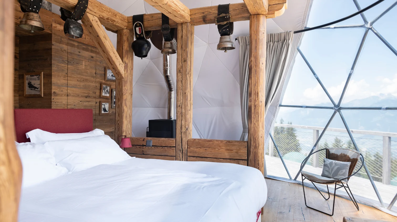 Lit en vieux bois et paroi vitrée ouverte sur les montagnes – Forum Magazine : retraite à Whitepod en Suisse