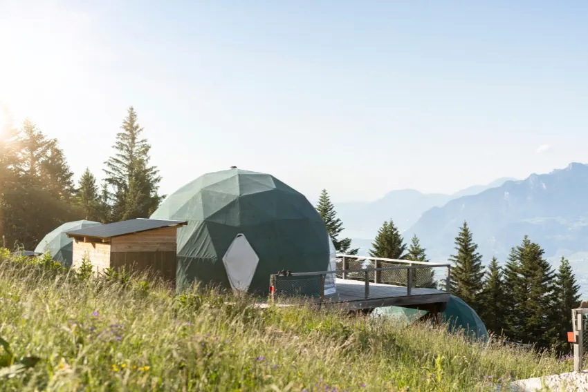 Pod en dôme vert sur l'alpage au lever du soleil – Forum Magazine : retraite à Whitepod en Suisse