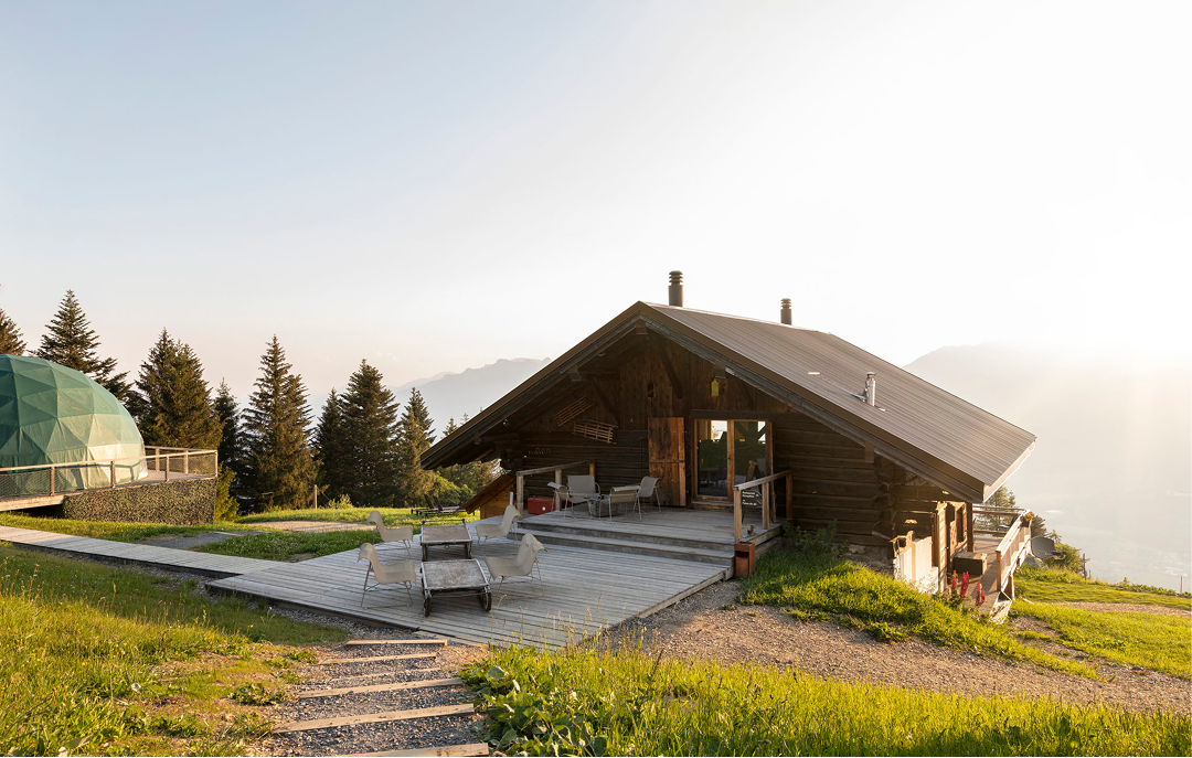 Chalet en bois sur un alpage au soleil couchant, un pod en arrière-plan – restaurant Les Cerniers au-dessus de Monthey