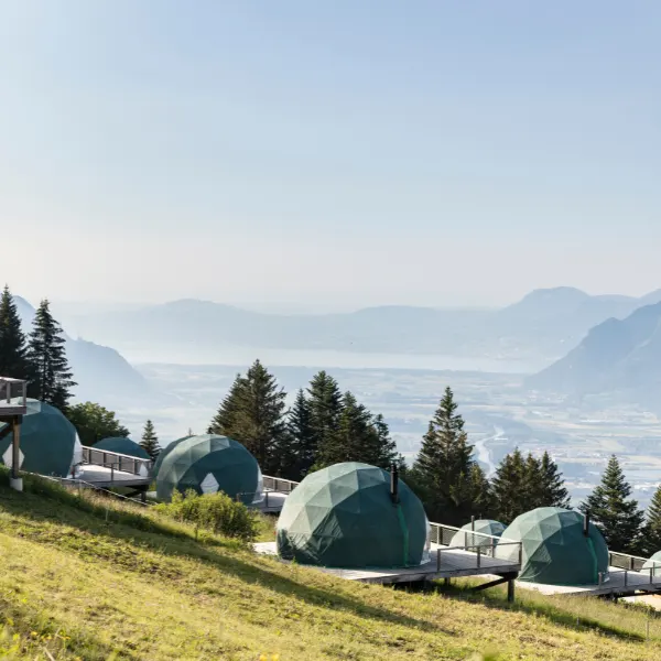 Pods en dôme sur un versant herbeux dominant la vallée et les montagnes – Forum Magazine : retraite à Whitepod en Suisse