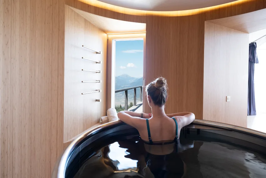 Frau im japanischen Bad vor einem Fenster mit Bergblick – Zen-Suite Pod, Pod von Whitepod in den Schweizer Alpen