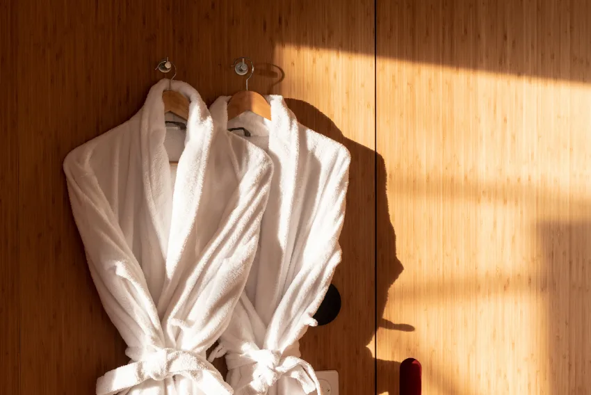 Zwei weiße Bademäntel an einer Holzwand – Zen-Suite Pod, Pod von Whitepod in den Schweizer Alpen