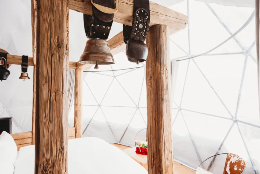 Kuhglocken an einem Balken unter der Pod-Struktur – Pod Suite Schweiz, Pod von Whitepod im Wallis