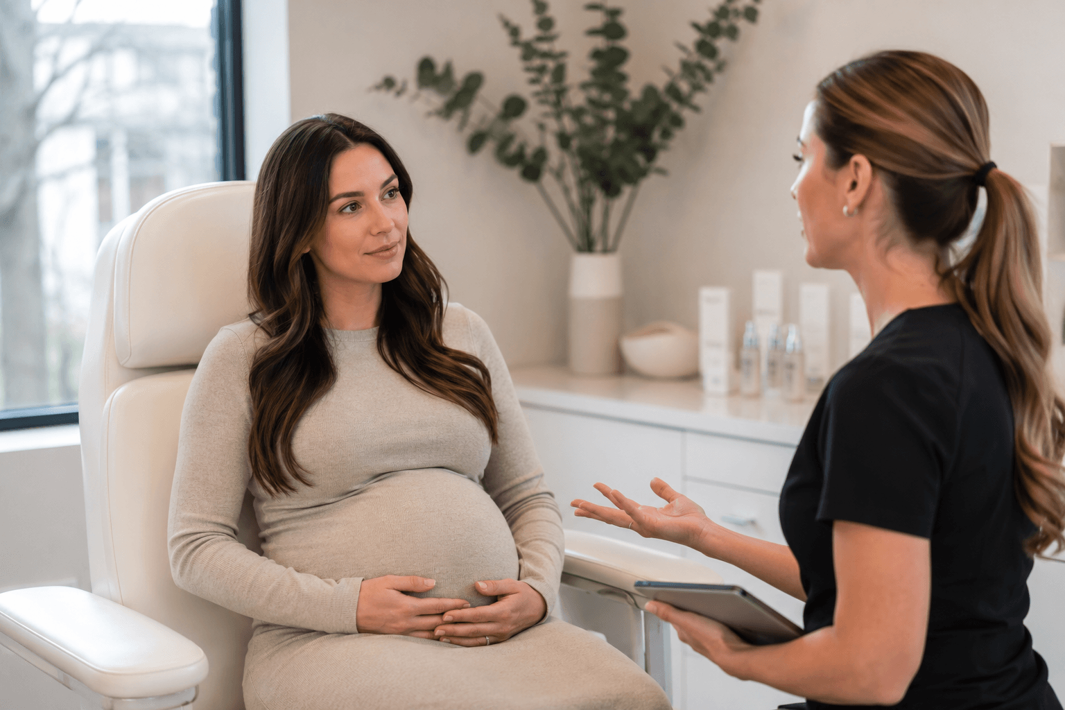 Pregnant woman speaking with an aesthetic provider about Botox safety during a consultation at a medical spa in Richardson, Texas.