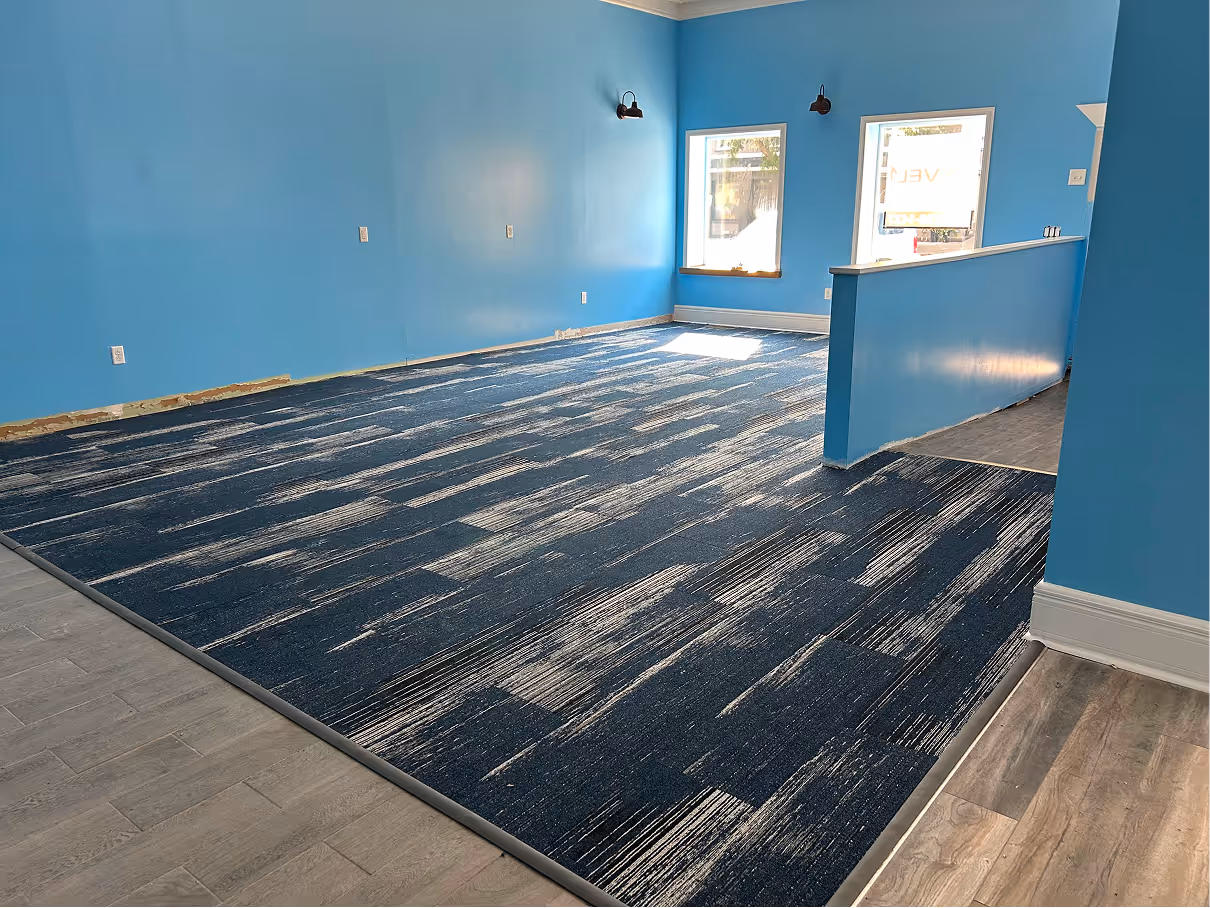 Daycare renovation showing framed half walls, new paint, and flooring transitions during construction.